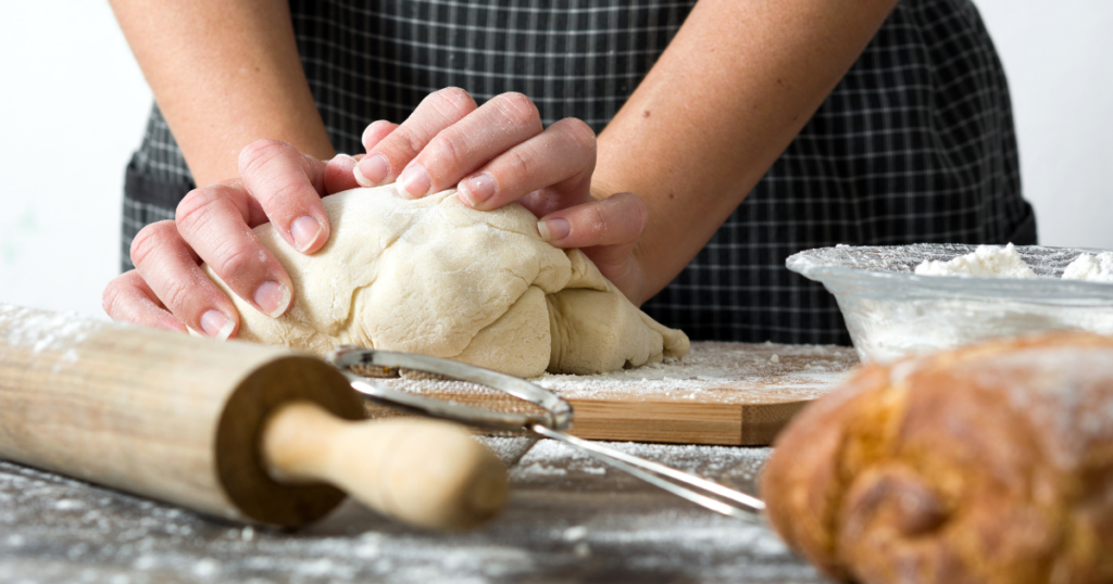 pair of hands kneading bread dough