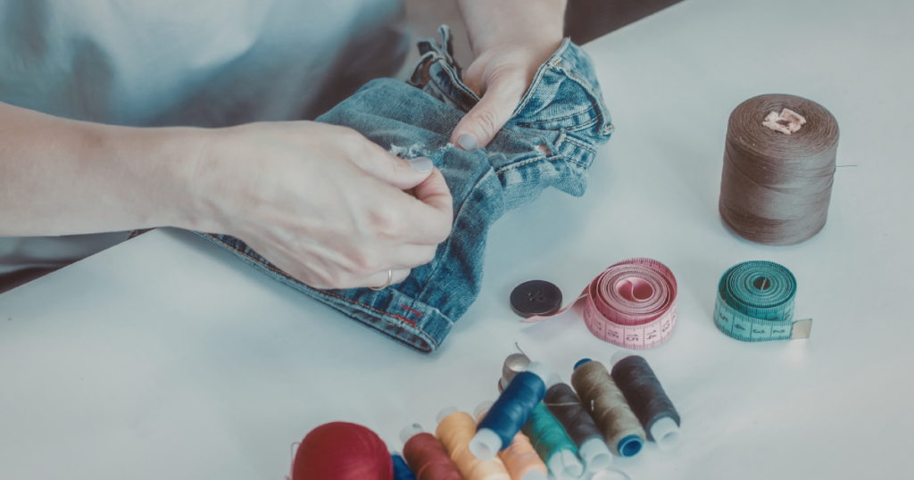 pair of hands mending jeans