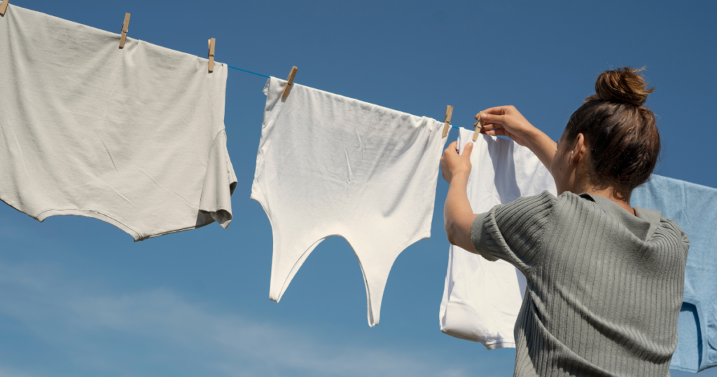 Woman hanging laundry out on a beautiful day. Old fashioned money saving tips are coming back into style in today's economy.
