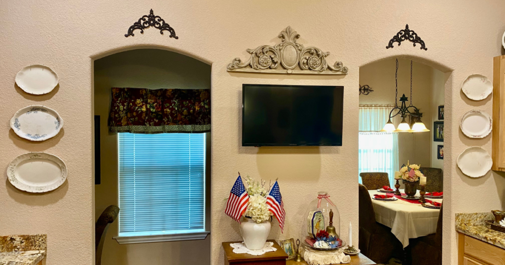 Collection of thrifted vintage platters displayed on a kitchen wall for affordable home decorating.
