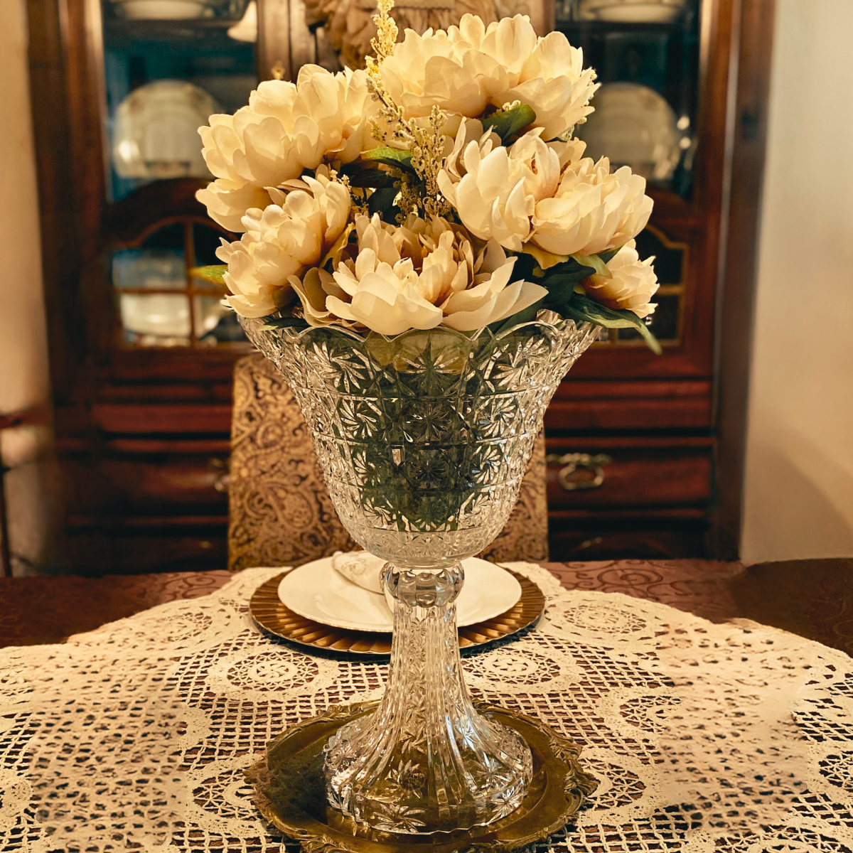 Crystal vase filled with flowers on dining room table in a cozy, welcoming home.